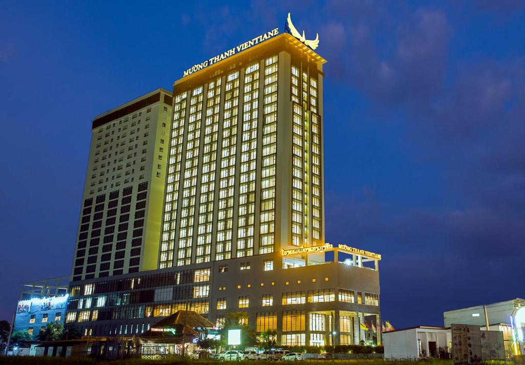 万象Muong Thanh Luxury Vientiane Hotel的一座高大的建筑,晚上有灯