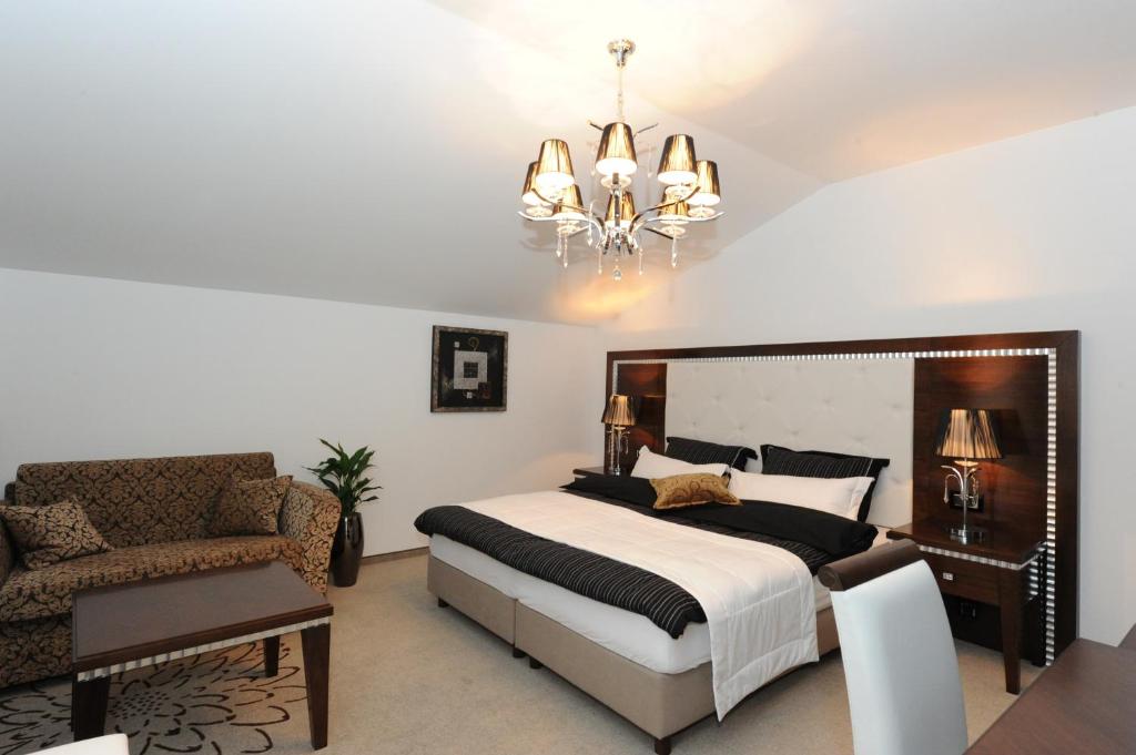 Sevnica多林塞克旅馆的一间卧室配有一张床、一把椅子和一个吊灯。