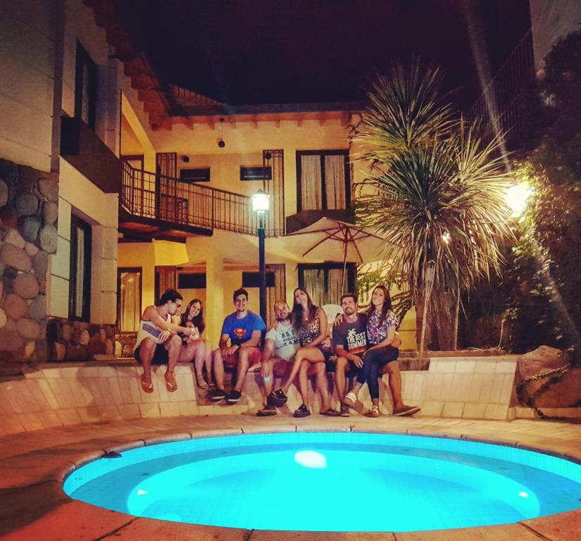 门多萨La Magdalena的一群人晚上坐在游泳池周围