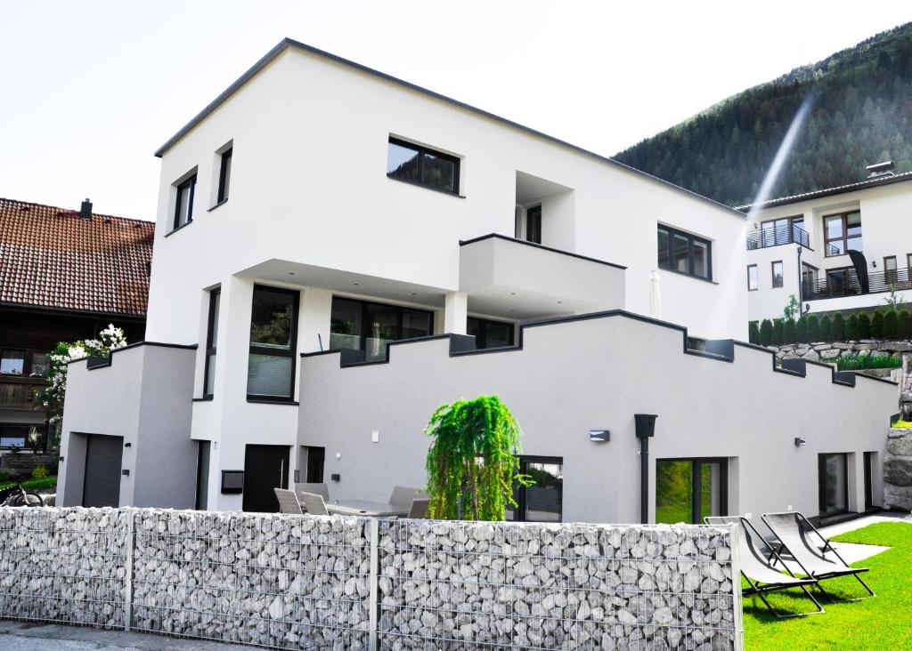 皮茨河谷阿兹尔Appartement Alpenzauber的白色的房子,设有石墙