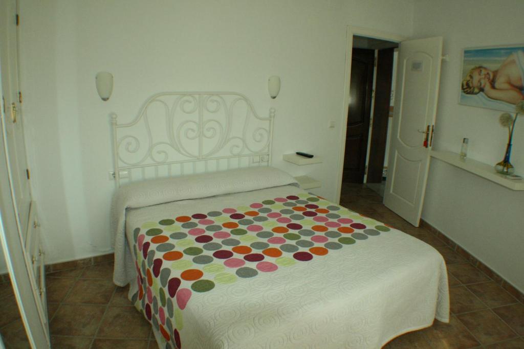 科尼尔-德拉弗龙特拉伊莎贝尔的角落旅馆的一间卧室配有一张带波卡圆毯的床