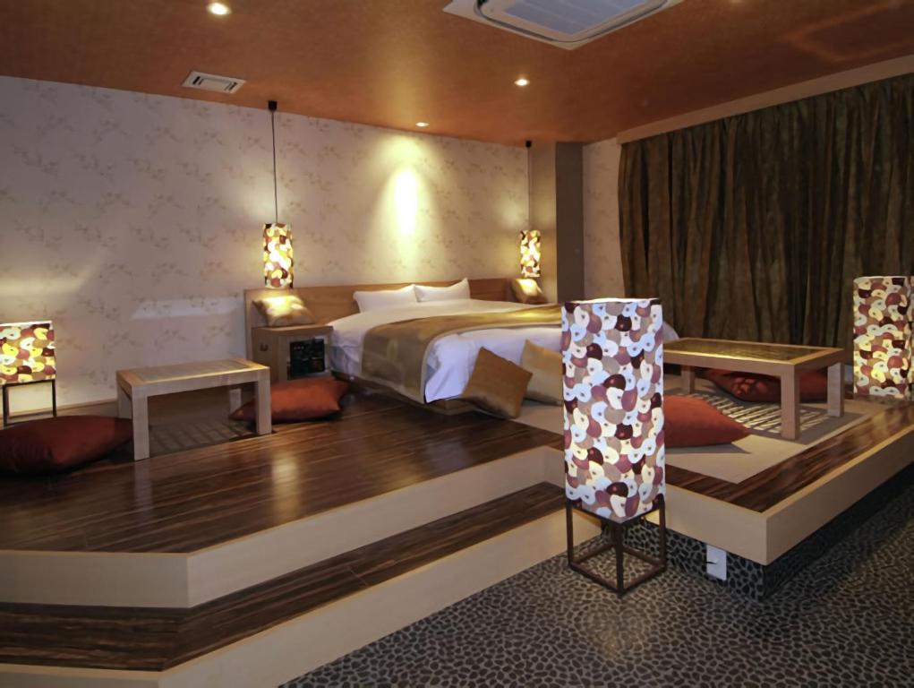 京都Hotel Cuna Kyoto Love Hotel的酒店客房,设有一张床和两张桌子