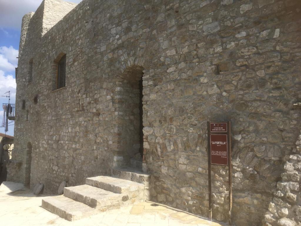 Oppido LucanoLa Portella的石墙,有楼梯,旁边有一个标志