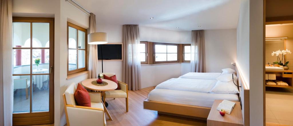 阿皮亚诺苏拉斯特拉达斯皮塔勒酒店 的配有一张床、一张桌子和一张桌子的酒店客房