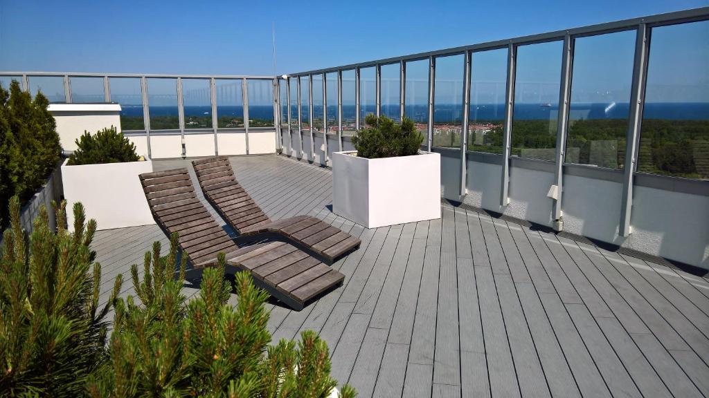 格但斯克ATapartments - Cztery Oceany I的阳台配有两把椅子,享有海景。