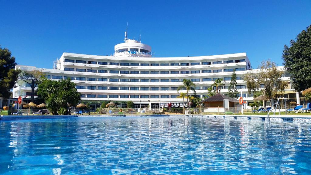 EsteponaTRH帕莱索酒店的大楼前设有游泳池的酒店