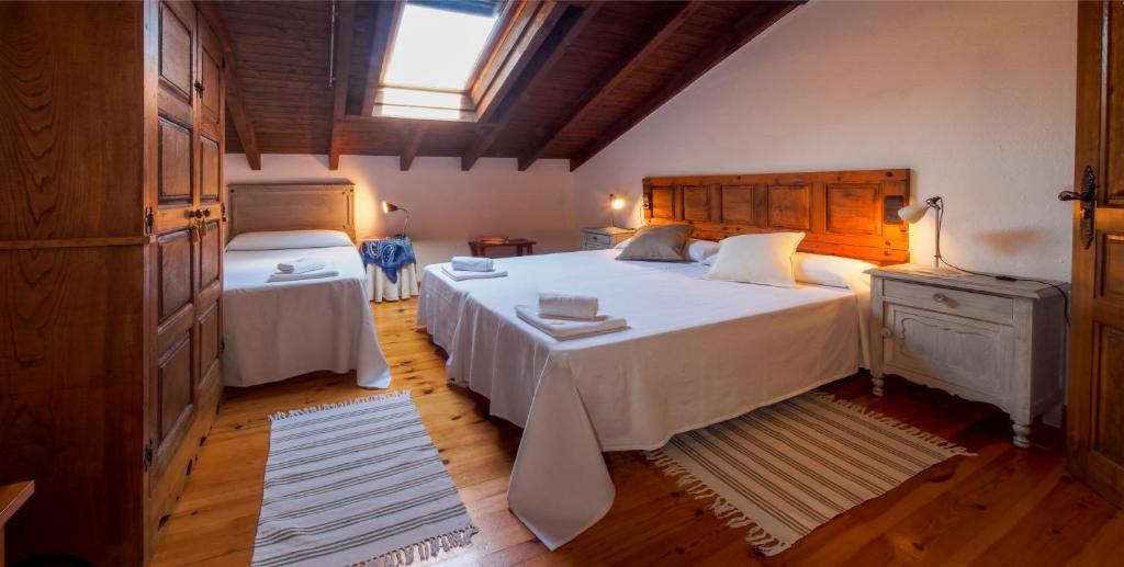 AvínCasa de la Montaña Albergue Turístico的卧室设有一张白色大床和一扇窗户。