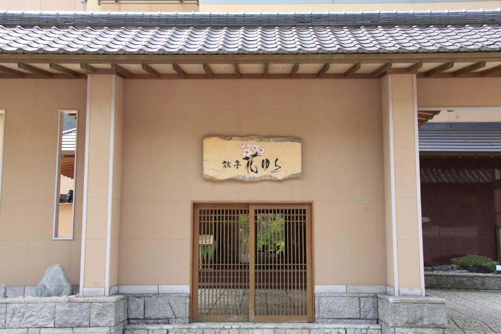 登别旅亭花由良日式旅馆 的通往大楼的大门,上面有标志