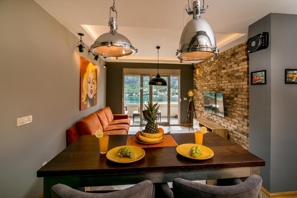 科托尔Apartments Magic Sea View的一间带木桌和椅子的用餐室