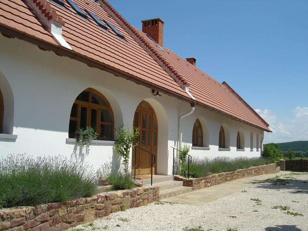 KékkútFerien im Naturschutzgebiet的白色的建筑,有拱门和红色的屋顶