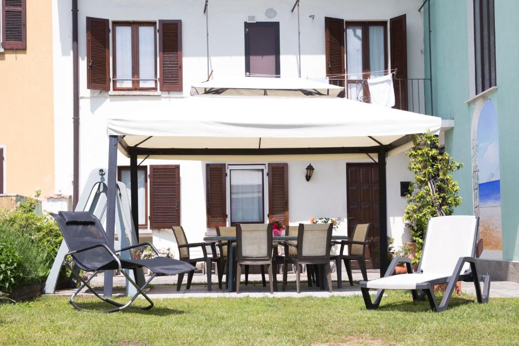 阿罗纳La Casa di Cristina的庭院配有桌椅和遮阳伞。