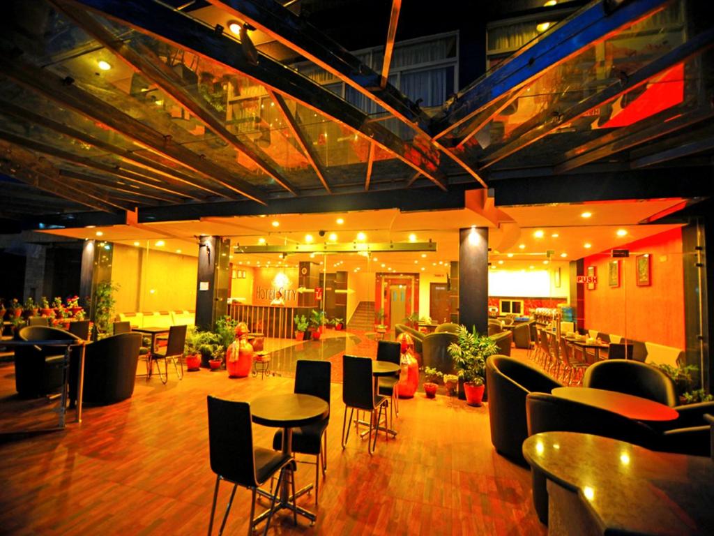 博卡拉Hotel City Inn - Mountain View的一间在房间内配有桌椅的餐厅
