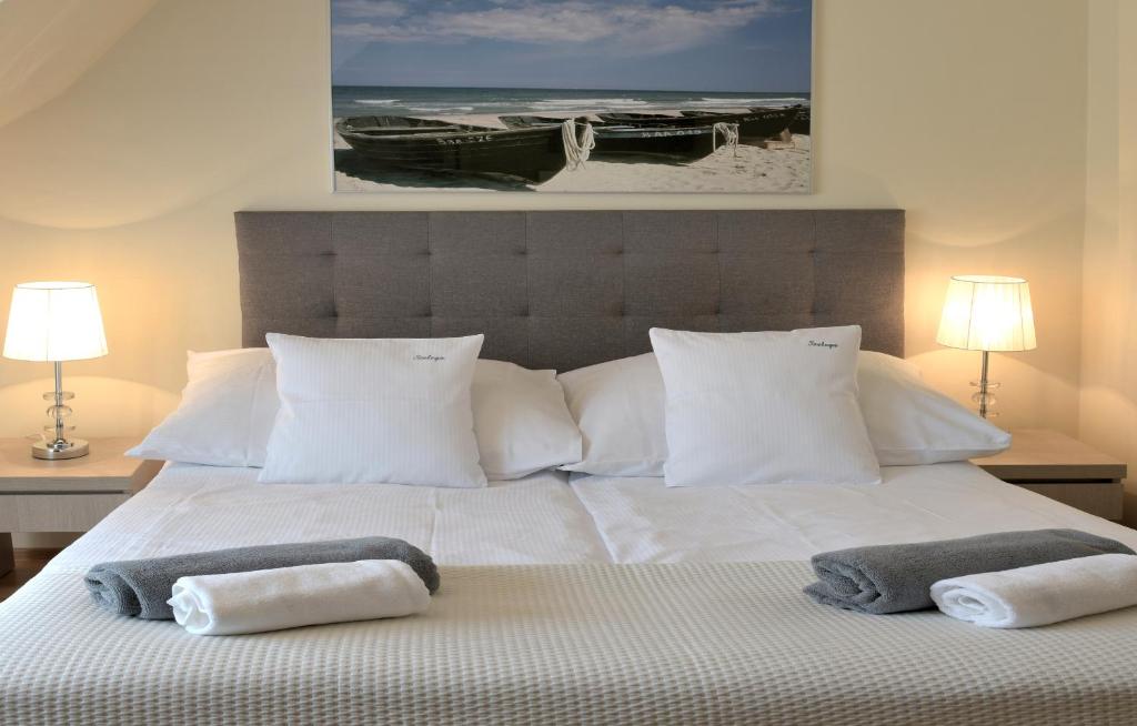 波别罗沃Villa Szelega的卧室配有白色床和毛巾