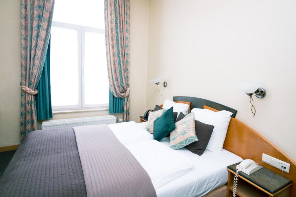 布兰肯贝赫Hotel Moby Dick by WP hotels的卧室配有带枕头的白色床和窗户。