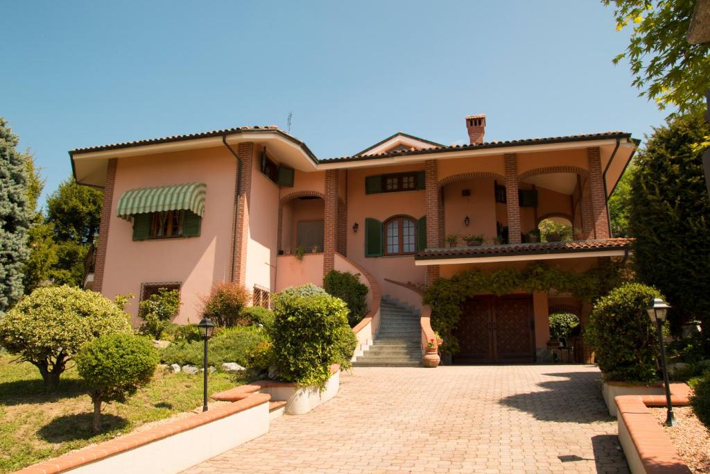 诺韦洛Villa Anselma的大型粉红色房屋,带车道