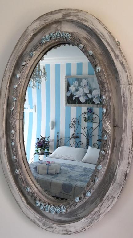努马纳Giglio Del Conero的墙上的镜子,房间里的床
