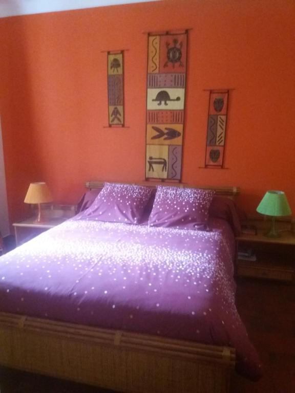 阿雅克修Villa Savane的一间卧室配有一张带两盏灯的紫色床