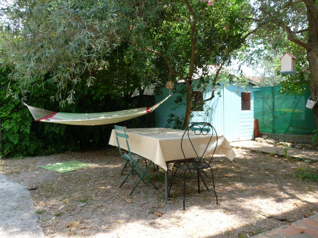 蒙彼利埃Montpellier Boutonnet avec jardin的树下桌子和椅子上的吊床