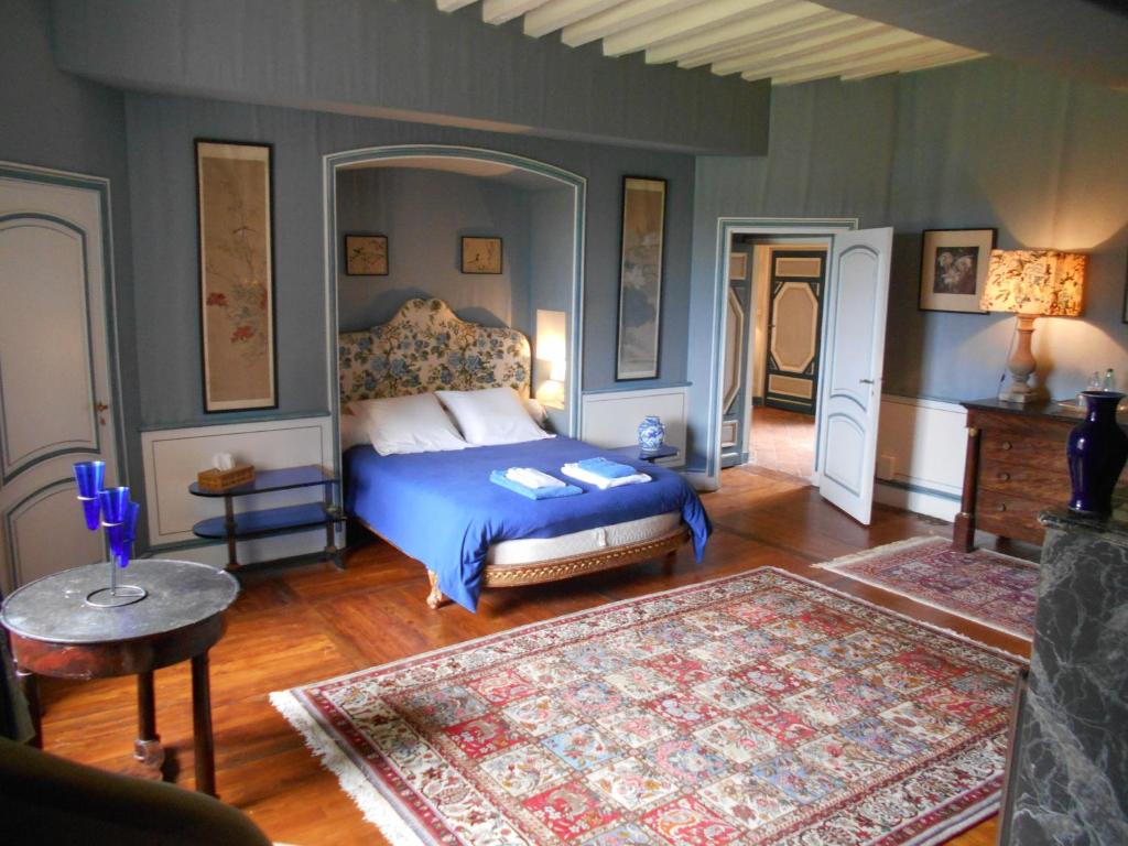 Parigny埃利拉城堡酒店的一间卧室配有一张带蓝色棉被的床