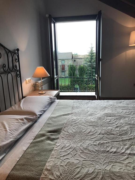 Abay卡萨坎普旅馆的一间卧室设有一张大床和大窗户