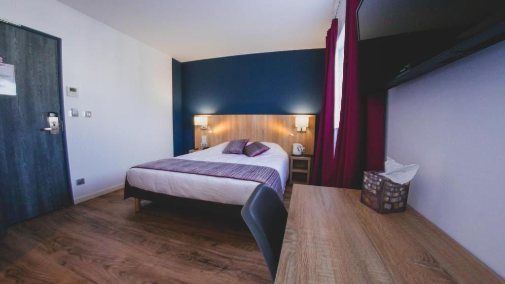 拉昂Hôtel du Tramway的一间卧室设有一张床和蓝色的墙壁