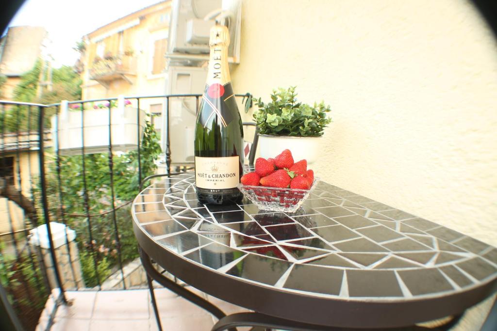 奥帕提亚Amorino Apartman Studio的一张桌子,上面放着一瓶葡萄酒和一碗草莓