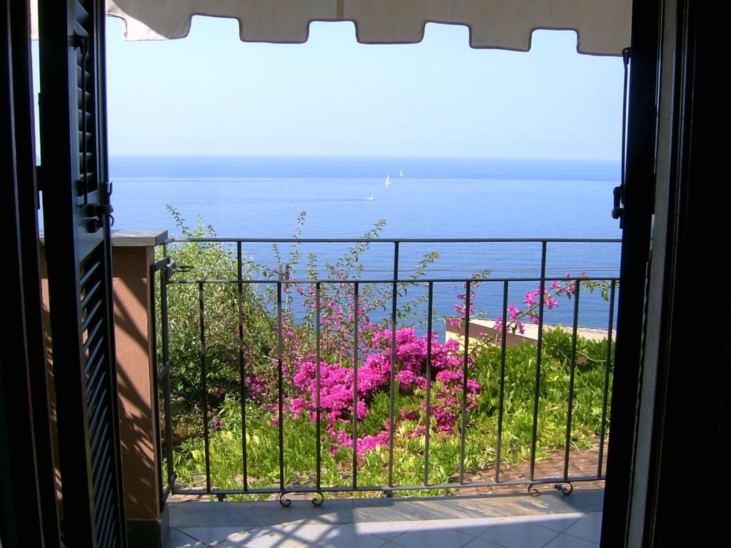 里奥马哲雷Casa Lorenza的阳台享有海景,拥有粉红色的鲜花
