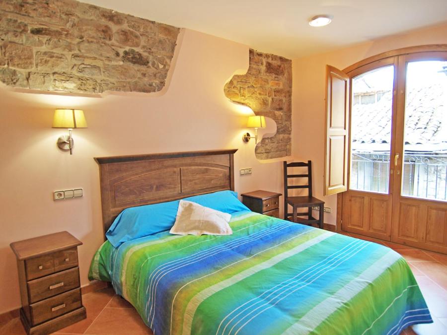 艾因萨Casa Fes Autural的一间卧室配有一张带彩色床罩的床