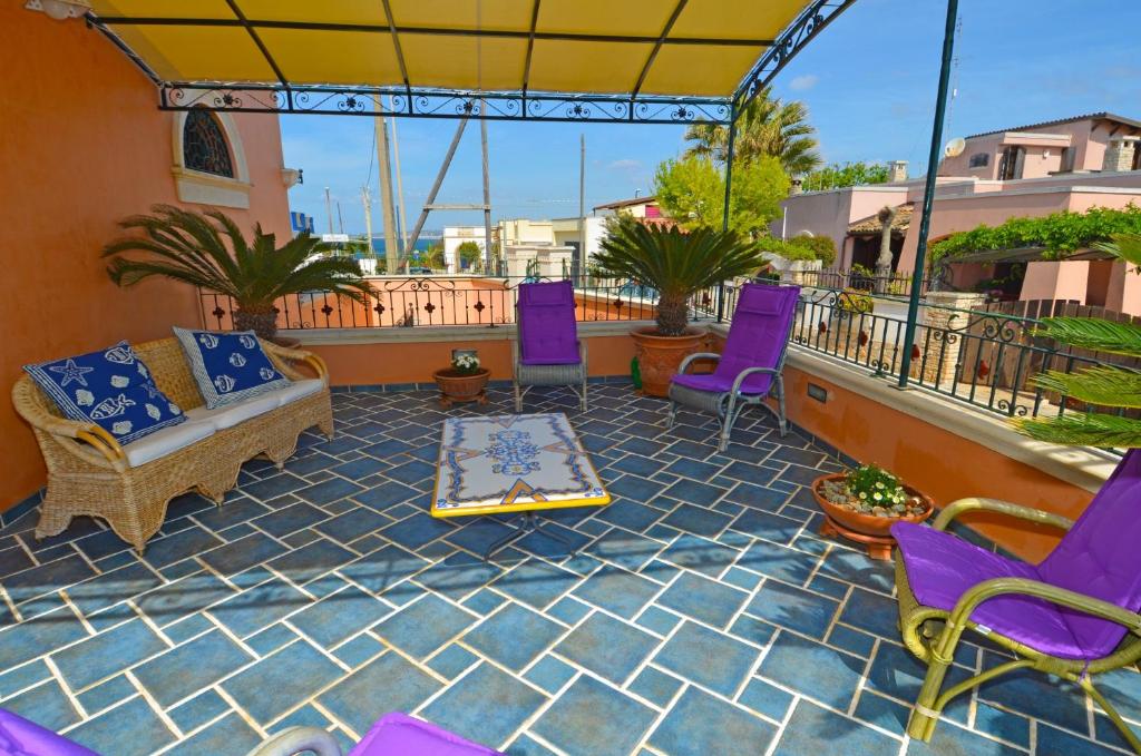 帕图Casa Spano 1 - RosariaVacanze的庭院配有紫色椅子、沙发和桌子