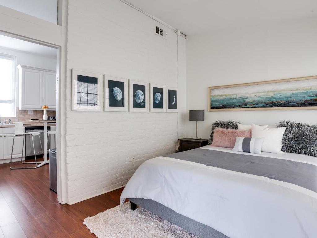 孟菲斯Downtown Memphis Shellcrest Apartments的白色卧室设有一张大床,墙上挂有图片