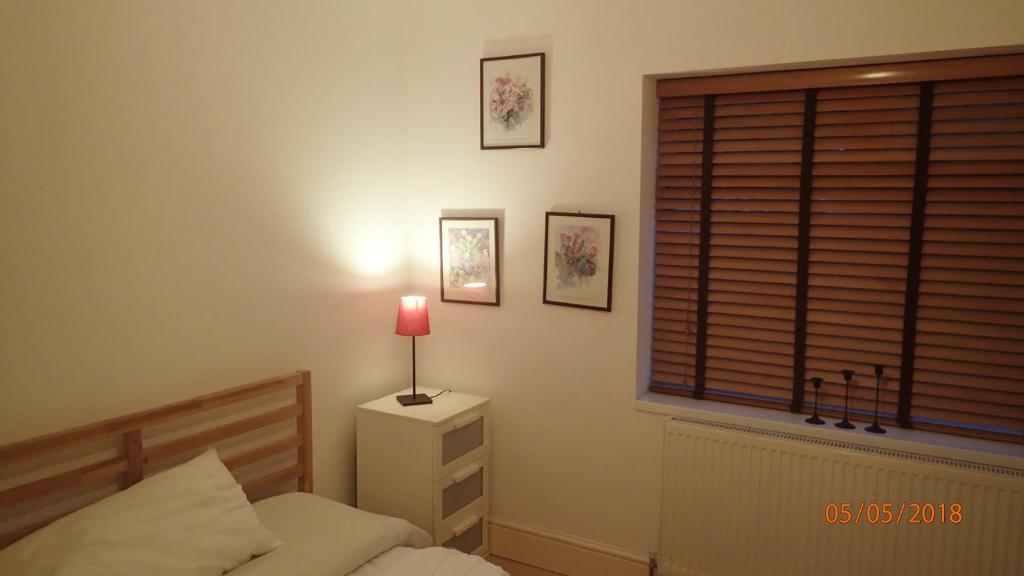 伦敦Hill Apartments的一间卧室,配有一张床和床头灯