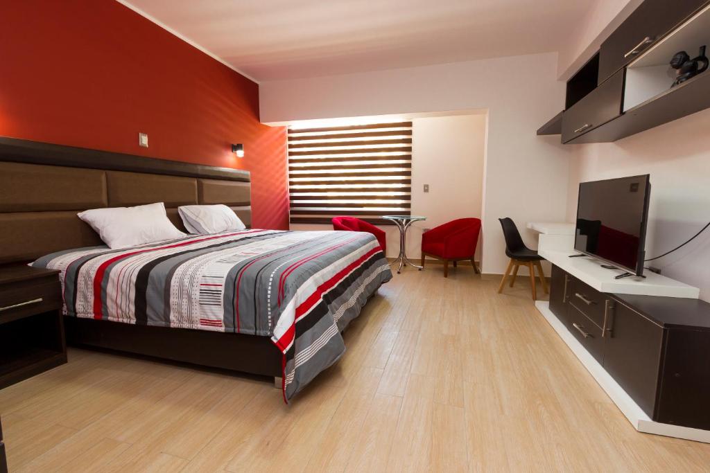 塔尔马Hotel Turin的一间卧室配有一张床、一张书桌和一台电视