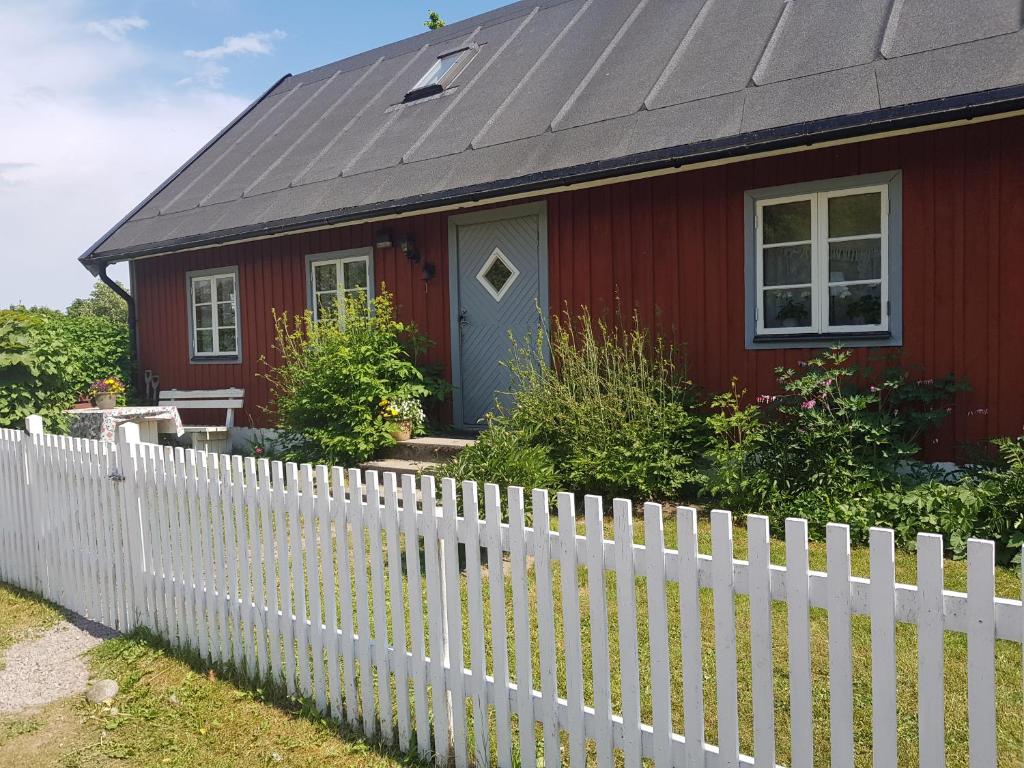 EljarödSmultronbacken的一座红色的房子,有白色的栅栏