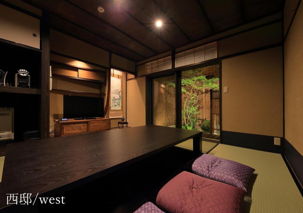 京都侯卡度假屋的一间带大桌子和粉红色椅子的用餐室