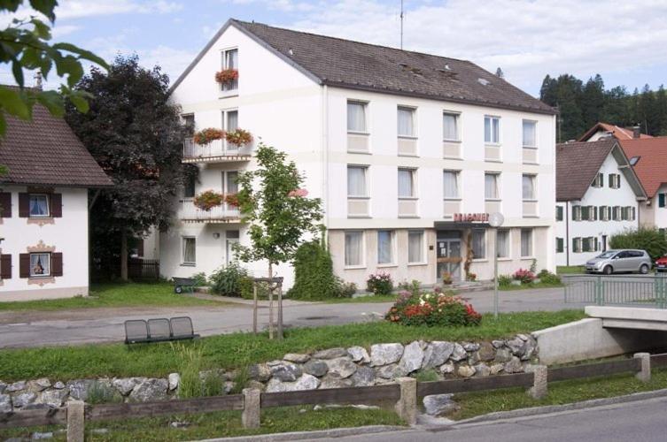派廷格Gästehaus an der Peitnach-Hotel Zum Dragoner的街道边的白色大建筑