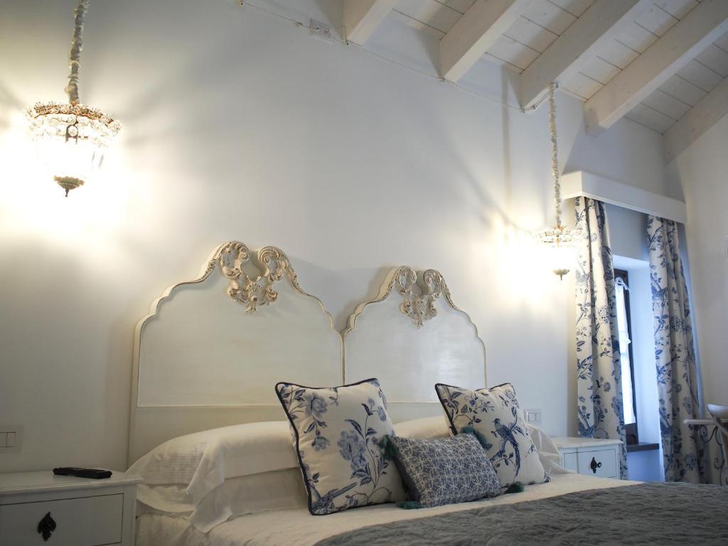 巴尔迪Le Sei Dame的白色卧室配有蓝色和白色枕头的床