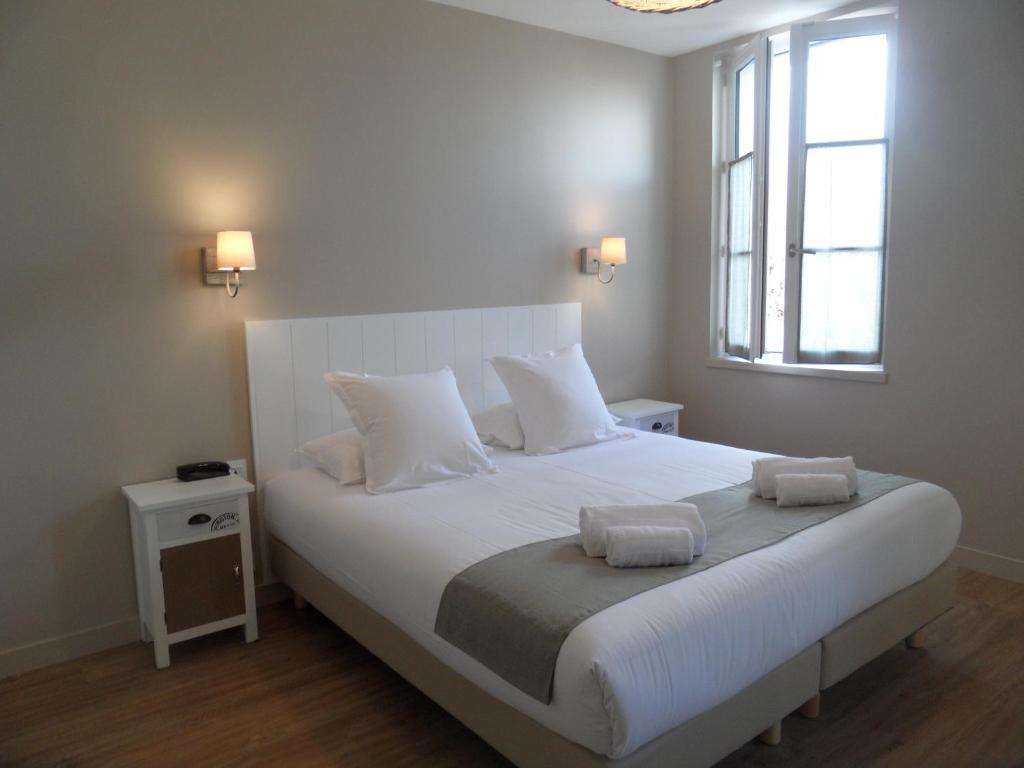 雷岛圣玛丽L'Escale的卧室配有一张白色大床和两条毛巾