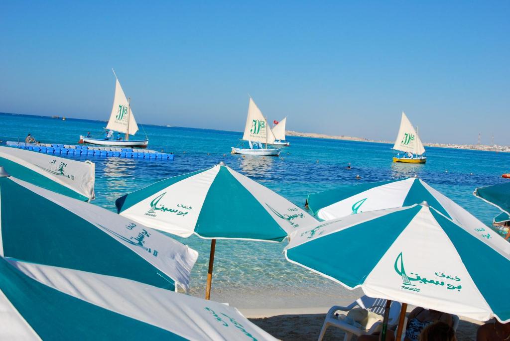 马特鲁港伯希特酒店的一群在海滩上的遮阳伞,在水中划船