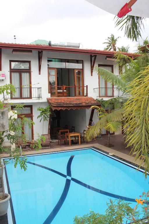 尼甘布卡普鲁别墅 的享有房屋和游泳池的景致。