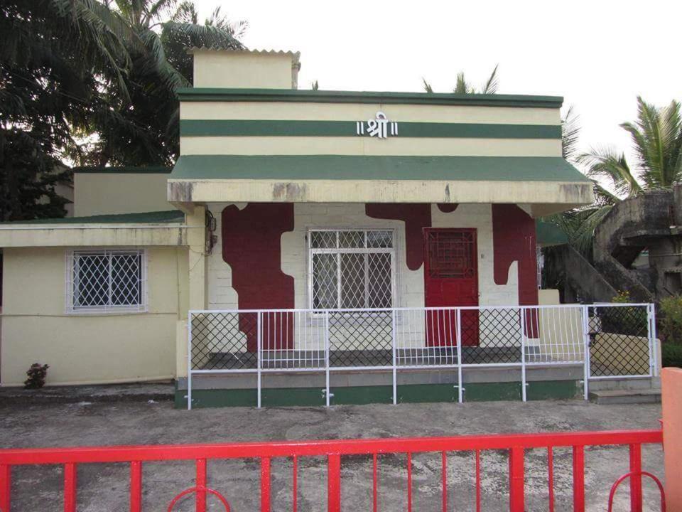 拉特纳吉里Shree Bungalow的前面有红墙的房子