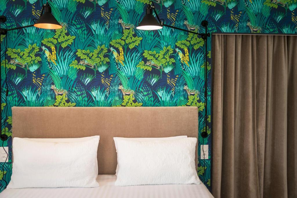 比亚里茨埃杜阿尔德七世酒店的一间卧室配有一张蓝色和绿色壁纸的床