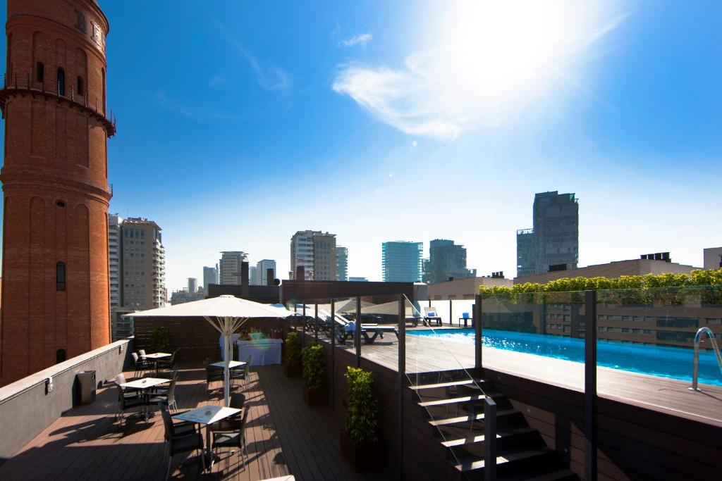 巴塞罗那阿提卡21号巴塞罗那马尔酒店的一个带游泳池和钟楼屋顶庭院