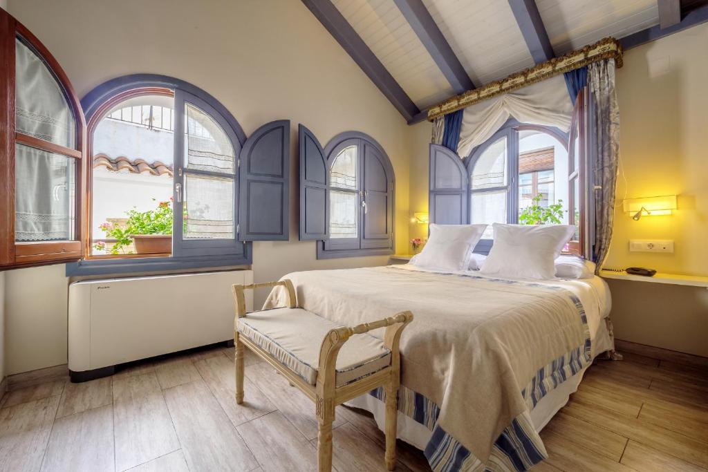 科尔多瓦阿尔贝卡豪华公寓套房的一间卧室配有一张床、一把椅子和窗户。