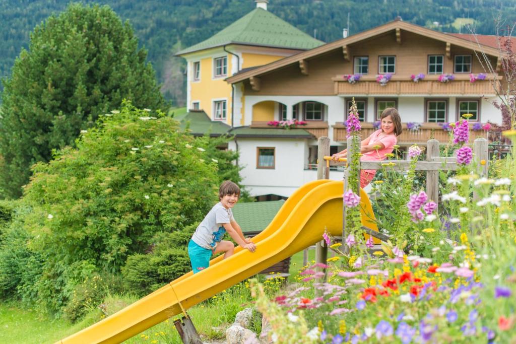 拉德施塔特胡本古特住宿加早餐旅馆的花园里滑梯上玩耍的男孩和女孩