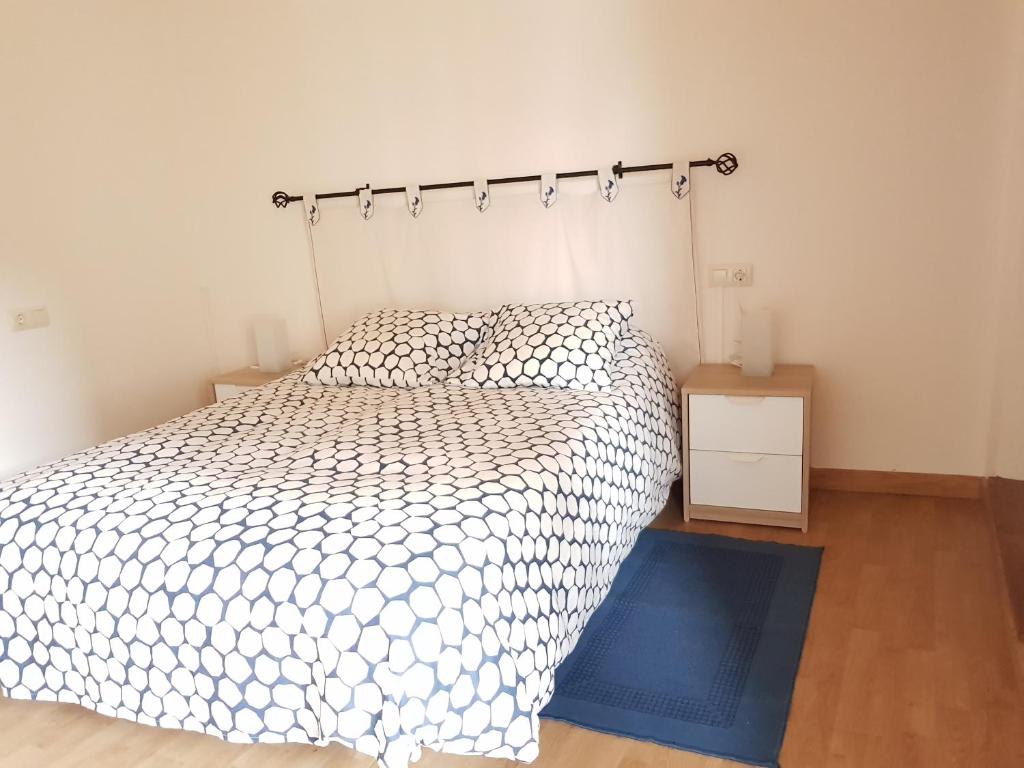 阿拉力兹Casa García的卧室配有白色的床和蓝色地毯。