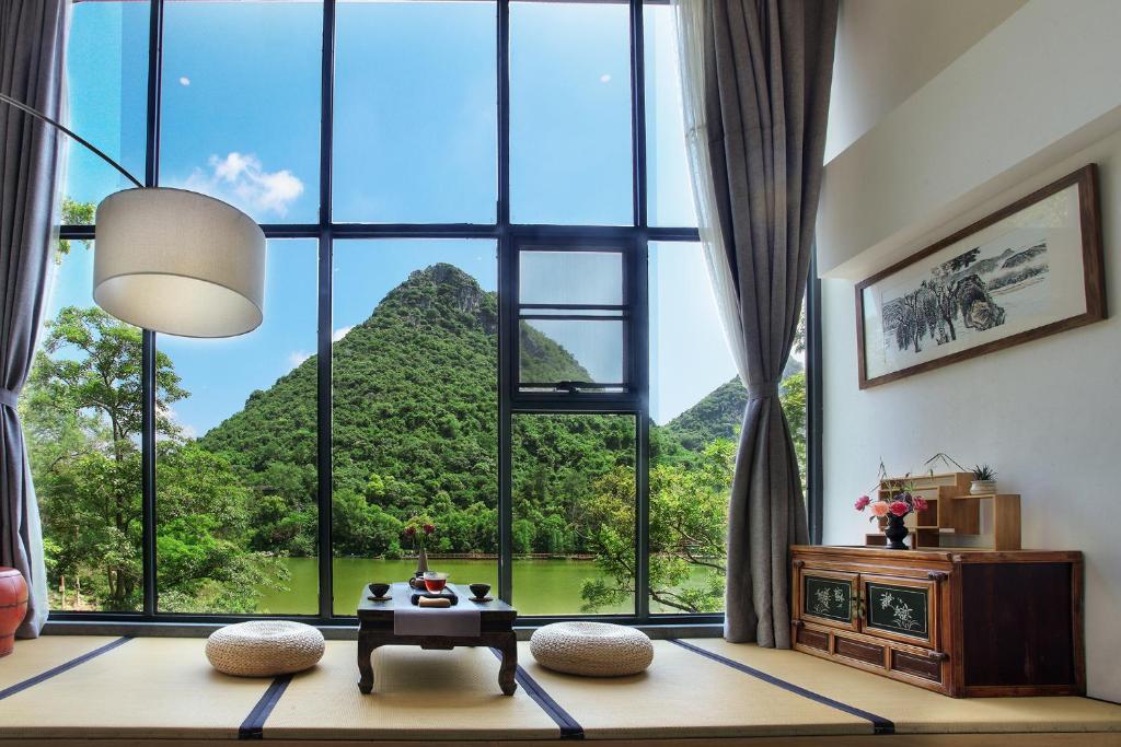 桂林桂林和舍湖畔度假酒店的客房设有山景大窗户。