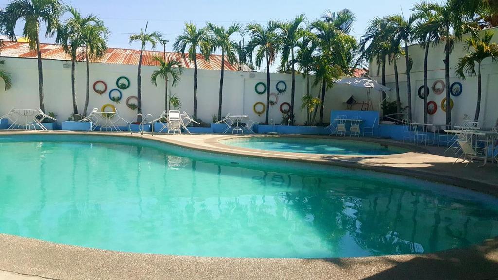 拉瓦格The Palacio de Laoag的棕榈树建筑前的大型游泳池