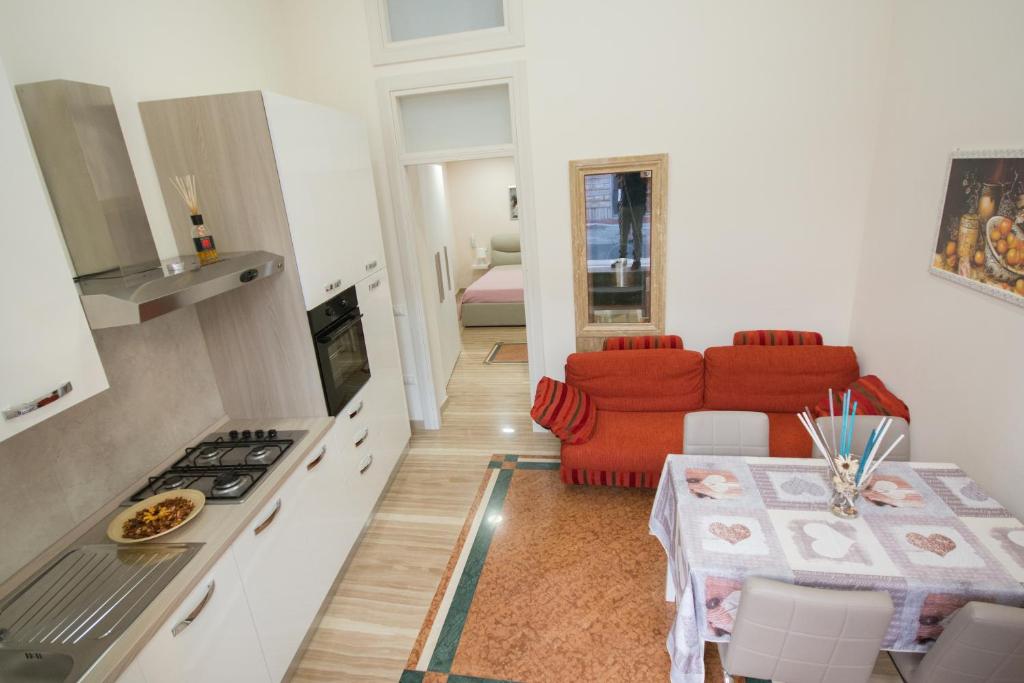 莱西纳Al Vecchio Fontanile的厨房以及带红色沙发的起居室。