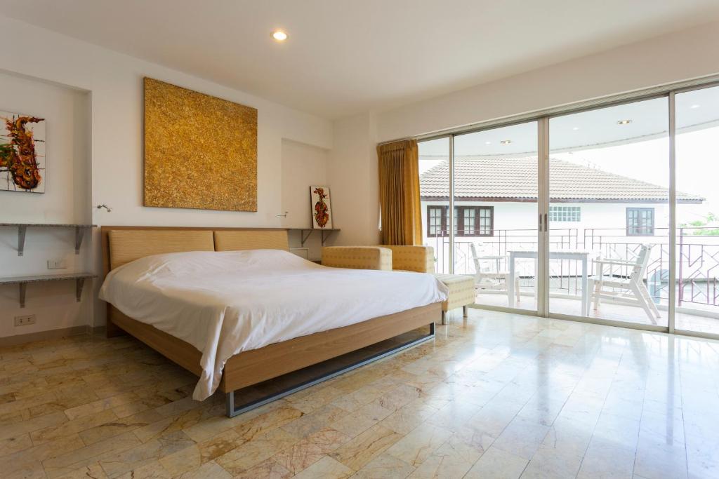清迈加拉里通塔公寓式酒店的一间卧室设有一张大床和大窗户
