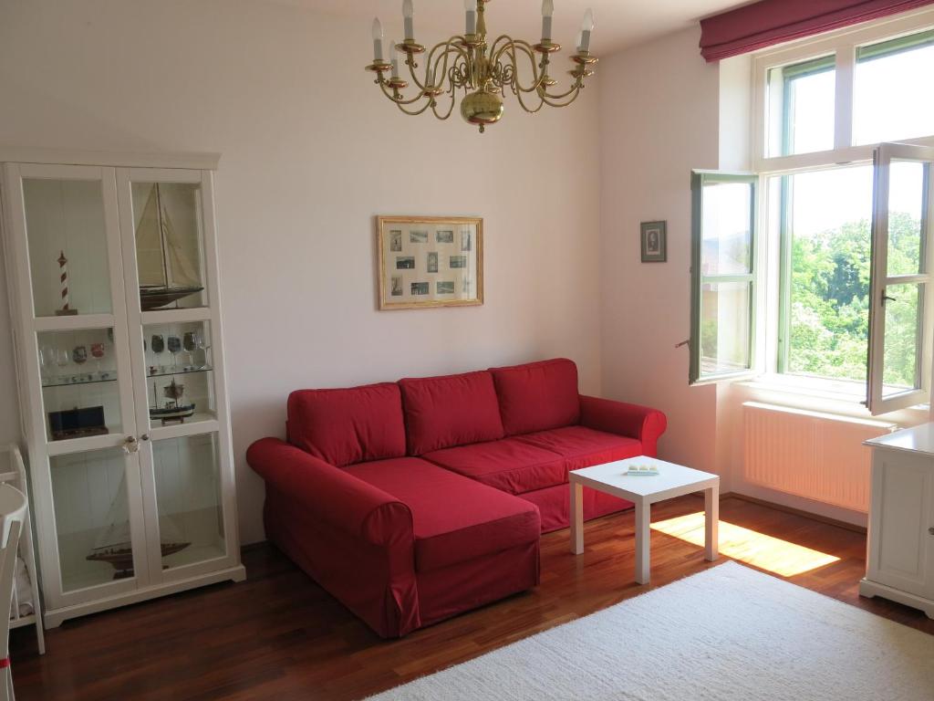 巴拉顿菲赖德Horvath Villa Apartman Aliz的客厅配有红色的沙发和桌子